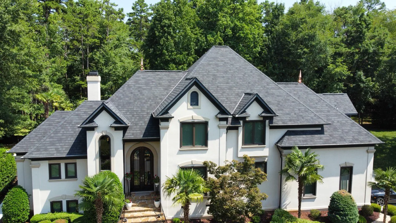 A completed Triumph Roofing project on a white home with architectural shingles