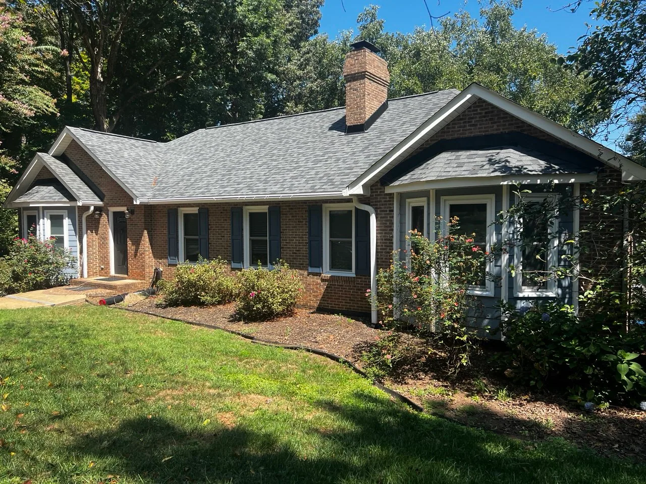 Completed shingle roof by Triumph Roofing on a brick home in Concord, North Carolina